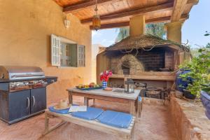 Una cocina al aire libre con una mesa y un horno. en Oasis San Martin El Cotillo, en Playa del Águila