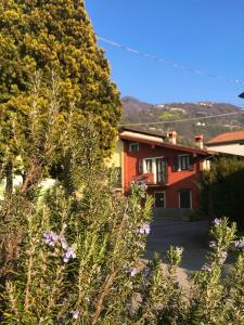 a house with trees and flowers in front of it at La casa rossa in Costa Volpino