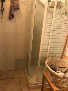 a shower in a bathroom with a basket on a table at La casa rossa in Costa Volpino