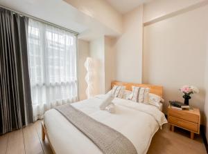 a bedroom with a bed with a large window at Stylish 1BR in OPR in Lapu Lapu City +32 photos