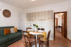 a living room with a table and a green couch at Su Scannu - Stylish Beach apartment with Lounge terrace in Quartu Sant'Elena