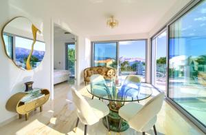 a living room with a glass table and chairs at Shimmer & Shine in Baška