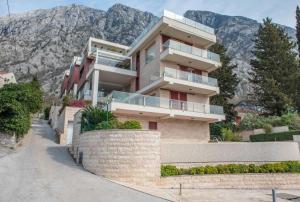 a house on a hill with mountains in the background at Apartment Marta in Ljuta