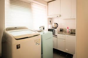 a kitchen with white cabinets and a refrigerator at Daechi Stay#Gangnam#COEX#Concert KSPO#강남세브란스병원#대치동학원가 in Seoul +10 photos
