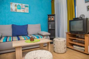 a living room with a couch and a tv at Apartman Katarina in Dramalj
