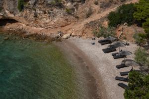 a group of chairs and umbrellas on a beach at Agrilia Koromili Retreat in Paralia Livadostratas