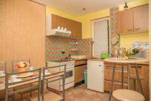 a kitchen with wooden cabinets and a white refrigerator at Apartman Katarina in Dramalj