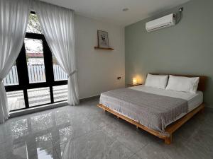 ein Schlafzimmer mit einem Bett und einem großen Fenster in der Unterkunft 189 Landed HomeStay Johor Bahru in Kampong Saleng