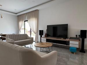 ein Wohnzimmer mit Sofa und Fernseher in der Unterkunft 189 Landed HomeStay Johor Bahru in Kampong Saleng