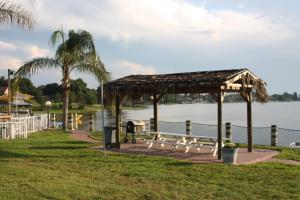 a picnic area with a pavilion next to the water at Lake Roy Beach Inn - Winter Haven in Winter Haven