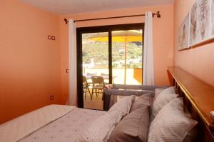 a bedroom with a bed and a view of a patio at Casa La Erita in Valle Gran Rey