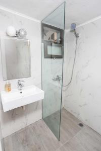 a bathroom with a sink and a glass shower at Stratos Angels apartments in Pefkohori