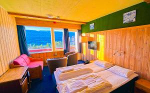 a bedroom with a bed and a table and chairs at Lia Fjellhotell in Geilo