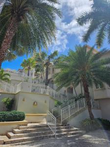 a building with stairs and palm trees in front at Cozy Studio in TCI in Providenciales