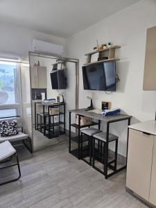 a living room with a table and a tv on the wall at Cozy Studio in TCI in Providenciales