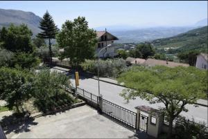 a view of a house with a fence and trees at B&B Camposauro in Vitulano