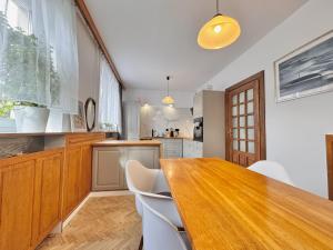 a kitchen with a wooden table and white chairs at Willa Tradycja 2 in Gdańsk