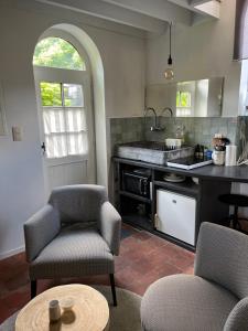 a kitchen with two chairs and a table at La Très Petite Tour in Nivelles +11 photos