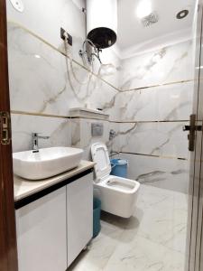 un bagno bianco con lavandino e WC di Homlee-Diamond 2BHK Lift-Parking-Max Vaishali a Ghaziabad Altre 14 foto