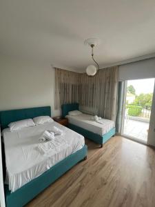 a bedroom with two beds and a large window at Hotel Athina in Asprovalta