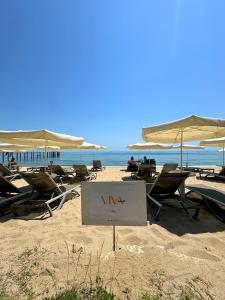 a sign on a beach with chairs and umbrellas at HVD Viva Club Ultra All Inclusive - Private Beach & Free Parking in Golden Sands