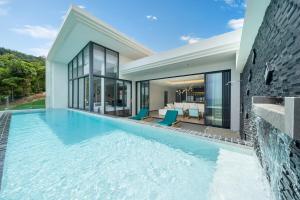 a swimming pool in the backyard of a house at The Exclusive Sky D1 豪华4卧室海景别墅 私人12m无边海景泳池 每日清洁 in Kamala Beach