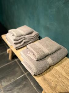 a pile of towels sitting on a wooden table at La Très Petite Tour in Nivelles