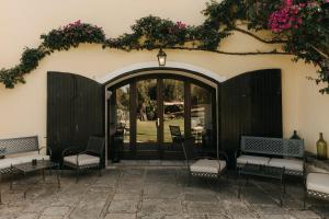 a patio with chairs and a door with flowers at Casa Qafiz  +35 photos