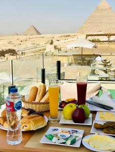 开罗sekhmet pyramids view的金字塔顶上有一张桌子，上面摆着食物和饮料