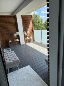 a large deck with a bench and a table at AKOYA APARTMENT Cristal Bianco in Koszalin