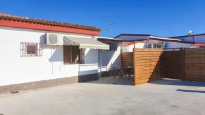 a white house with a fence and a patio at Casa Algodon in Chiclana de la Frontera