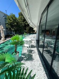 un patio extérieur avec tables, chaises et plantes dans l'établissement Vila Natalia, à Eforie Nord