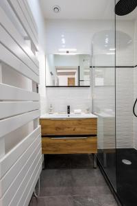 une salle de bain avec un lavabo et un miroir dans l'établissement L'Opale - Duplex Calme & Confort en Hypercentre, à Castres