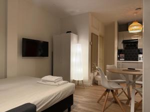 a bedroom with a bed and a table with a chair at Central Studios in The Hague +15 photos
