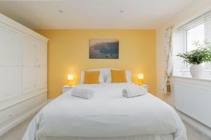 a bedroom with a large white bed with two lamps at St Marks Cottage in Swanage