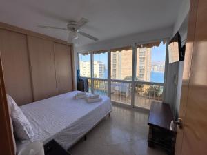 sypialnia z łóżkiem i dużym oknem w obiekcie Beautiful 2 bedrooms Apartment in Agua Mundo w mieście Benidorm