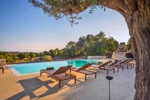Un grupo de tumbonas junto a una piscina. en A Casa Ruah - IsulaTravel, en Scuola