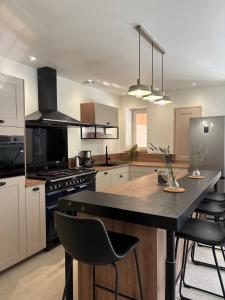 eine Küche mit einer großen Insel mit Stühlen darin in der Unterkunft La marmotte in Le Vanneau