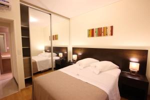 1 dormitorio con 2 camas y un espejo grande en Lecer Apart en Buenos Aires