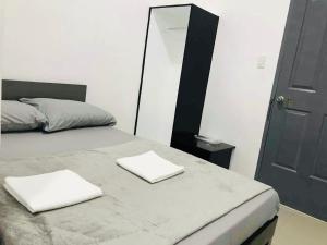 a bedroom with a bed with two white towels on it at Sea Bed's Inn in Glan