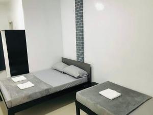a small room with two beds and a table at Sea Bed's Inn in Glan