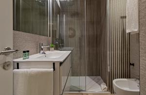 ein Badezimmer mit Waschbecken und Dusche in der Unterkunft Apartamentos Suites Oficentro Original in Málaga + 42 Fotos