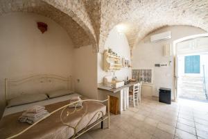 een slaapkamer met een bed en een bureau in een kamer bij Jacuzzi IV Monte romantic suite with hot tub in Ceglie Messapica