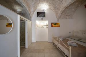 een slaapkamer met een bed in een kamer met een stenen plafond bij Jacuzzi IV Monte romantic suite with hot tub in Ceglie Messapica