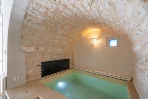een zwembad in een kamer met een stenen muur bij Jacuzzi IV Monte romantic suite with hot tub in Ceglie Messapica