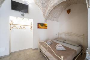 een slaapkamer met een bed en een tv aan de muur bij Jacuzzi IV Monte romantic suite with hot tub in Ceglie Messapica +10 foto's