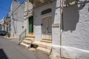 een wit gebouw met een deur en een trap op een straat bij Jacuzzi IV Monte romantic suite with hot tub in Ceglie Messapica