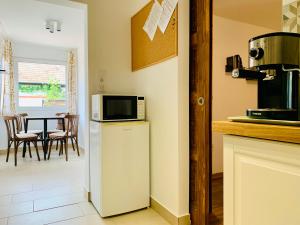 a kitchen with a microwave on top of a refrigerator at Dévér Apartman in Gárdony
