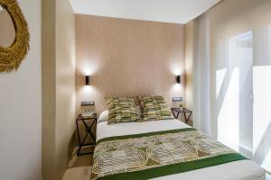 ein Schlafzimmer mit einem Bett mit zwei Kissen in der Unterkunft Apartamentos Suites Oficentro Original in Málaga