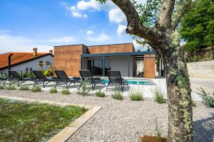 a house with a swimming pool and a tree at Casa Pianta in Buzet - Haus für 6 Personen in Buzet